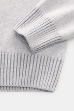 Close-up top-down view of Gran Sasso Cashmere turtleneck sweater light blue mélange showing pure cashmere, very soft feel, medium-fine knit pattern, regular fit, fitted turtleneck, and comfortable ribbed cuffs.