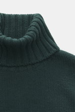 Close-up front view of B.F. Knitwear Merino turtleneck jumper dark green, showing pure merino wool, soft feel, semi chunky knit, slim fit, ribbed turtleneck, and flexible ribbed bands.