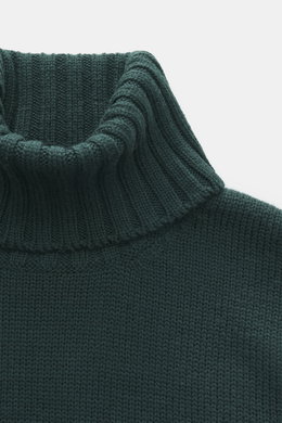 Close-up front view of B.F. Knitwear Merino turtleneck jumper dark green, showing pure merino wool, soft feel, semi chunky knit, slim fit, ribbed turtleneck, and flexible ribbed bands.