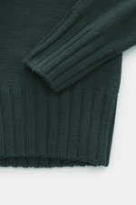 Close-up top-down view of B.F. Knitwear Merino turtleneck jumper dark green sleeve and hem showing pure merino wool, soft feel, semi chunky knit, slim fit, ribbed turtleneck, and flexible ribbed bands.
