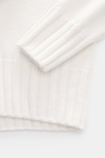 Close-up top view of B.F. Knitwear Merino turtleneck jumper off-white sleeve and cuff showing pure merino wool, soft feel, semi chunky knit, slim fit, ribbed turtleneck, and flexible ribbed bands.