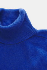 Nahaufnahme des anliegenden Rollkragens vom B.F. Knitwear Cashmere Rollkragenpullover blau, mittelfeines Strickbild, reiner Cashmere, Slim Fit, elastische Rippstrick-Bündchen, weich gestrickt, italienische Herstellung.