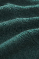 Close-up texture view from above of B.F. Knitwear Cashmere Turtleneck Sweater dark green in soft pure cashmere with medium-fine knit. Autumnal cashmere by the knitting expert B.F. KNITWEAR: This softly knitted turtleneck sweater is the perfect addition to
