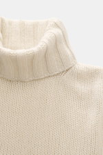 Close-up front view of B.F. Knitwear Cashmere turtleneck sweater cream showing coarse knit texture, fitted turtleneck, and elastic ribbed cuffs.