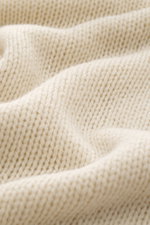 Close-up front view of B.F. Knitwear Cashmere turtleneck sweater cream showing coarse knit texture and soft touch of pure cashmere.