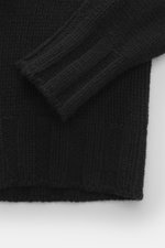 Close-up front view of B.F. Knitwear Cashmere turtleneck sweater black showing coarse knit texture, fitted turtleneck, and elastic ribbed cuffs.

Description: <p>Autumnal cashmere from the knitting expert B.F. KNITWEAR: This softly knitted turtleneck swea