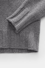 Close-up, top-down view of the B.F. Knitwear Cashmere turtleneck sweater grey melange showing its coarse knit texture and elastic ribbed cuffs.

Description: <p>Autumnal cashmere from the knitting expert B.F. KNITWEAR: This softly knitted turtleneck sweat