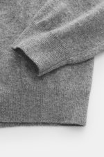 Close-up top-down view of Aida Barni Cashmere turtleneck sweater grey melange showing pure cashmere, soft feel, fine knit pattern, slim fit, close-fitting turtleneck, and flexible ribbed cuffs.