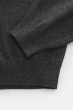 Close-up top-down view of Aida Barni Cashmere turtleneck sweater dark grey melange sleeve and cuff showing fine knit pattern, soft pure cashmere, slim fit, close-fitting turtleneck, and flexible ribbed cuffs. Italian knitwear by AIDA BARNI: With a timeles