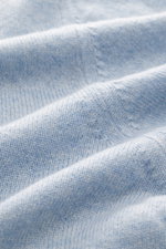 Close-up view of Aida Barni Cashmere turtleneck sweater light blue melange, showing fine knit pattern and soft pure cashmere fabric texture.