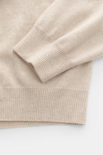 Close-up side view of the Aida Barni Cashmere turtleneck sweater sand melange sleeve and cuff showing pure cashmere, soft feel, fine knit pattern, slim fit, close-fitting turtleneck, and flexible ribbed cuffs.