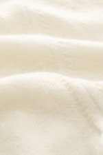 Close-up view of the Aida Barni Cashmere turtleneck sweater cream, showcasing pure cashmere with a soft feel, fine knit pattern, slim fit, close-fitting turtleneck, and flexible ribbed cuffs, photographed from a detailed fabric perspective. Italian knitwe