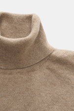 Close-up front view of Aida Barni Cashmere turtleneck sweater beige melange showcasing pure cashmere, soft feel, fine knit pattern, slim fit, close-fitting turtleneck, and flexible ribbed cuffs, Italian knitwear for autumn/winter.