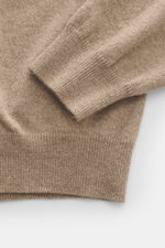 Close-up top-down view of Aida Barni Cashmere turtleneck sweater beige melange showing fine knit pattern, slim fit, close-fitting turtleneck, and flexible ribbed cuffs made of pure cashmere with a soft feel.