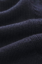 Nahaufnahme des mittelgroben Strickbilds vom Della Ciana Rollkragenpullover navy, fotografiert von oben, Mix aus Wolle und Cashmere, weicher Griff, Slim Fit, Rollkragen, komfortable Rippbündchen.