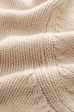 Nahaufnahme aus schräger Perspektive des beigefarbenen Della Ciana Rollkragenpullovers mit mittelgrobem Strickbild, weichem Griff, Slim Fit, Mix aus Wolle und Cashmere und komfortablen Rippbündchen.