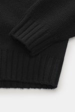 Nahaufnahme des Della Ciana Rollkragenpullovers schwarz von oben, zeigt Slim Fit, mittelgrobes Strickbild, weichen Griff, Rollkragen, Rippbündchen, Mix aus Wolle und Cashmere.