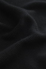 Nahaufnahme des schwarzen Della Ciana Rollkragenpullovers aus Wolle und Cashmere, weicher Griff, mittelgrobes Strickbild, Slim Fit, Rollkragen, komfortable Rippbündchen, Detailansicht.