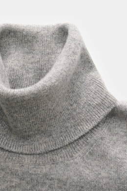 Nahaufnahme des anliegenden Rollkragens vom Brunello Cucinelli Cashmere Rollkragenpullover grau meliert aus reinem Cashmere mit feinem Strickbild, komfortablen Rippbündchen und Kontrastkante, fotografiert von oben.