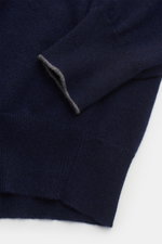 Brunello Cucinelli Cashmere Rollkragenpullover navy aus reinem Cashmere, feines Strickbild, Regular Fit, Nahaufnahme von Ärmel mit Kontrastkante und Rippbündchen.
