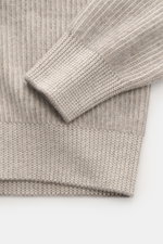 Close-up top view of the beige Brunello Cucinelli Cashmere Mockneck Sweater showing patent knit, slim fit, and ribbed cuffs.