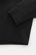 Close-up view of the Ami Paris Merino Turtle Neck Sweater Black showing fine knit pattern, ribbed cuffs, and hem from the side. Timeless basic: The AMI PARIS turtle neck sweater made of pure merino wool is a comfortable companion for office and leisure.
-