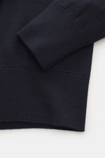 Close-up front view of the Ami Paris Merino Turtle Neck Sweater Navy showing pure merino wool knit, ribbed cuffs, fine pattern, and hem. Timeless basic: The AMI PARIS turtle neck sweater made of pure merino wool is a comfortable companion for office and l