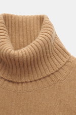 Close-up front view of Ami Paris Cashmere Turtleneck Sweater Light Brown showing fitted turtleneck, medium fine knit, soft touch, ribbed cuffs, cashmere with wool, regular fit, and logo stitching on hem.