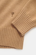 Close-up front view of Ami Paris Cashmere Turtleneck Sweater Light Brown showing logo stitching on hem, soft touch cashmere with wool content, medium fine knit pattern, regular fit, fitted turtleneck, and comfortable ribbed cuffs.