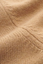 Close-up image of Ami Paris Cashmere Turtleneck Sweater Light Brown from above, showing cashmere with wool content, soft touch, medium fine knit pattern, regular fit, fitted turtleneck, logo stitching on the hem, and comfortable ribbed cuffs.