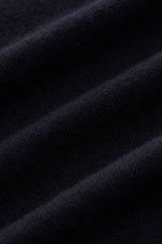 Close-up image of fabric texture photographed from a side angle showing the very fine knit pattern of the Kiefermann Merino Fine Knit Sweater 'Malt' navy, made of pure merino wool with a super soft touch, slim fit, high crew neckline, and elastic sleeve c
