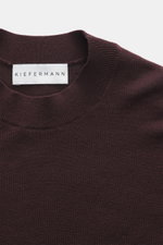 Close-up top view of Kiefermann Merino Fine Knit Sweater 'Malt' burgundy showing pure merino wool, super soft touch, very fine knit pattern, slim fit, high crew neckline, and elastic sleeve cuffs.