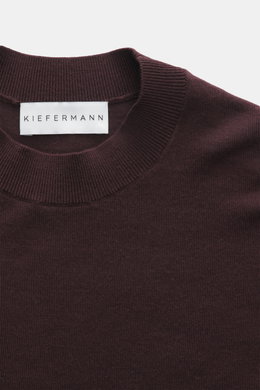 Close-up top view of Kiefermann Merino Fine Knit Sweater 'Malt' burgundy showing pure merino wool, super soft touch, very fine knit pattern, slim fit, high crew neckline, and elastic sleeve cuffs.