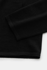 Close-up top-down view of the sleeve and hem of the Kiefermann Merino fine knit sweater 'Malt' black, featuring pure merino wool, super soft touch, very fine knit pattern, slim fit, high crew neckline, and elastic sleeve cuffs.