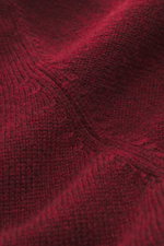 Nahaufnahme des feinen Strickbilds des bordeauxfarbenen Filippo de Laurentiis Cashmere Rollkragenpullovers, fotografiert aus schräger Perspektive, zeigt weichen Griff, reinen Cashmere, Regular Fit, Rollkragen in Rippstrick und flexible Rippbündchen – luxu