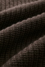 Nahaufnahme des mittelgroben Patent-Strickmusters des Allude Mock Neck Pullover dunkelbraun aus Wolle und Cashmere mit weichem Griff, fotografiert aus schräger Perspektive.