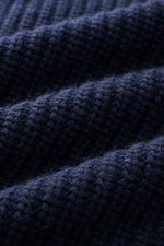 Nahaufnahme des Allude Mock Neck Pullover navy mit mittelgroßem Patent-Strickmuster, weichem Griff, Rippbündchen, Stehkragen, Raglan-Ärmeln, Regular Fit, Woll-Cashmere-Mix, fotografiert aus leichter Seitenperspektive.
