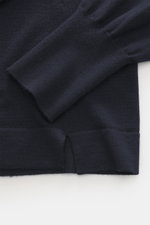 Nahaufnahme des Officine Générale Merino Rollkragenpullovers 'Nina' navy, zeigt Saum mit kurzen Schlitzen und breite, gerippte Ärmelbündchen, weiches feines Strickbild, reine Merinowolle, Slim Fit, anliegender Rollkragen, doppelt gearbeitete Saumabschlüss
