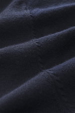 Nahaufnahme aus schräger Perspektive des dunkelblauen Officine Générale Merino Rollkragenpullovers 'Nina' navy mit feinem Strickbild und weichem Griff aus reiner Merinowolle.