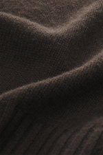 Nahaufnahme des FTC Cashmere Rollkragenpullovers dunkelbraun aus reiner Cashmere, mit geschmeidigem Griff, mittelfeinem Strickbild, Slim Fit, Rollkragen und komfortablen Rippbündchen, fotografiert aus schräger Perspektive.