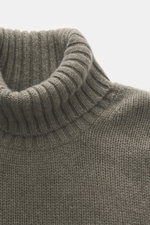 Nahaufnahme des FTC Cashmere Rollkragenpullovers graugrün meliert, von schräg oben fotografiert, weicher, mittelfeiner Strick, Rollkragen, Slim Fit, OEKO-TEX® zertifiziert, nachhaltiger Luxus.