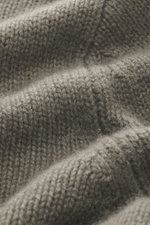 Nahaufnahme des mittelfeinen Strickbilds vom FTC Cashmere Rollkragenpullover graugrün meliert, nachhaltiger Luxus, weiche Haptik.