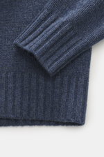 Nahaufnahme des FTC Cashmere Rollkragenpullovers graublau meliert von oben fotografiert, zeigt Slim Fit, weichen Griff, mittelfeines Strickbild, Rollkragen und Rippbündchen, nachhaltig und OEKO-TEX®-zertifiziert.
