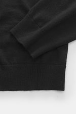 Nahaufnahme des FTC Feinstrick-Rollkragenpullovers schwarz, Detailansicht von Ärmel und Saum, Mix aus Fair-Trade-Cashmere und Lyocell, geschmeidiger Griff, feines Strickbild, Slim Fit, anliegender Rollkragen, komfortable Rippbündchen.