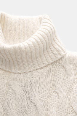 Nahaufnahme des Moorer Rollkragenpullovers 'Gordon' creme mit schwerem Zopfmuster, Rollkragen und flexiblem Rippbündchen, Perspektive von oben.
