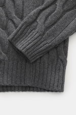 Nahaufnahme des Moorer Rollkragenpullovers 'Gordon' dunkelgrau meliert mit klassischem Zopfmuster, grobem Strickbild, anliegendem Rollkragen und flexiblen Rippbündchen, aus Wolle-Cashmere-Mix, fotografiert von oben.