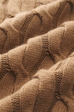 Nahaufnahme aus schräger Perspektive des Moorer Rollkragenpullover 'Gordon' hellbraun mit klassischem Zopfmuster aus Wolle-Cashmere-Mix, weichem Griff, grobem Strickbild, Regular Fit, anliegendem Rollkragen und flexiblen Rippbündchen, Made in Italy.