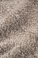 Nahaufnahme des feinen Stricks in Melange-Optik vom Moorer Rollkragenpullover 'Dacre' weiß/taupe meliert, Detail der Raglan-Ärmel und elastischen Rippbündchen aus Wolle und Cashmere, weicher Griff, Slim Fit, anliegender Rollkragen.