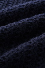 Nahaufnahme des Closed Mock-Neck Pullover navy, fotografiert aus schräger Perspektive, zeigt edlen Wollstrick mit markantem Strukturstrick.