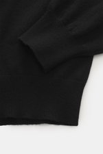 Nahaufnahme des Ärmels und Saums vom BRAUN Hamburg Cashmere Rundhalspullover schwarz, feines Strickbild, Slim Fit, weicher Griff.